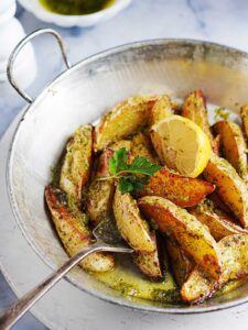 A vintage metal pan with Roasted Greek Potatoes.
